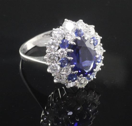 A modern 18ct white gold, sapphire and diamond oval cluster dress ring, size O.